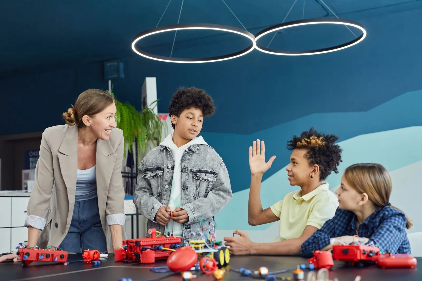 Enseignante accompagnant des élèves lors d'un atelier de robotique et d'électronique